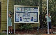 Pretty Beach School captains, Siann McPhee and Cosmo Porter-Witt raising the Australian and Aboriginal flags.